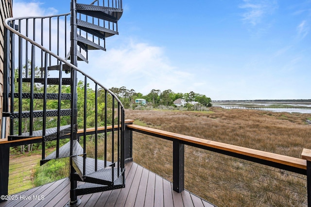 wooden deck with a water view and stairway