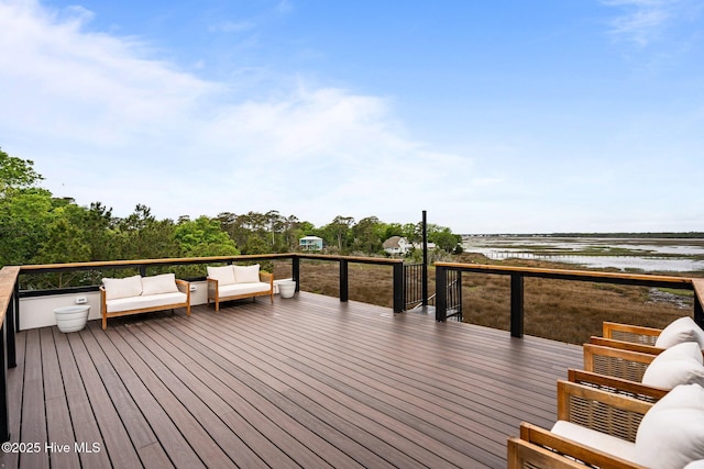 wooden terrace with a water view and outdoor lounge area