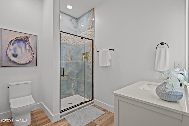 full bath with toilet, baseboards, a shower stall, and wood finished floors