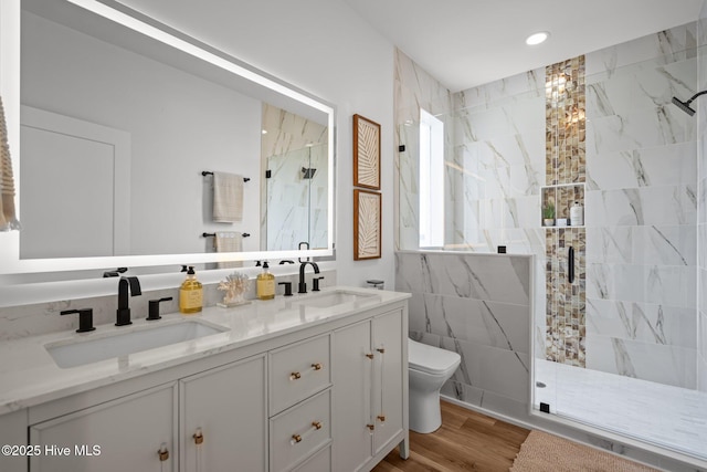 full bath featuring a sink, toilet, a marble finish shower, and recessed lighting