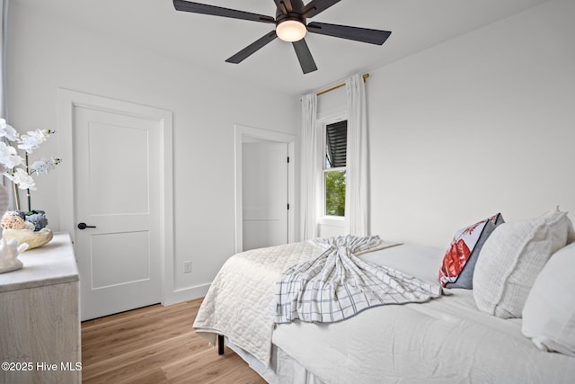 bedroom with baseboards, wood finished floors, and a ceiling fan