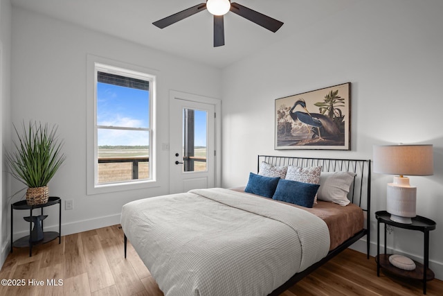 bedroom featuring ceiling fan, baseboards, and wood finished floors