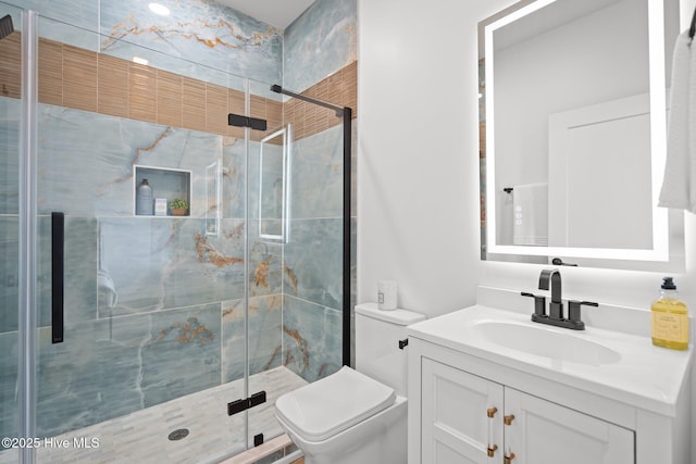full bathroom featuring a stall shower, vanity, and toilet