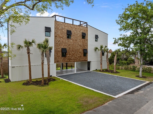 exterior space with gravel driveway, a lawn, and a carport