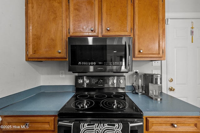 1114 Stone Creek Dr, Greenville, NC 27858 - kitchen featuring stainless steel microwave, electric range, brown cabinets, and dark countertops