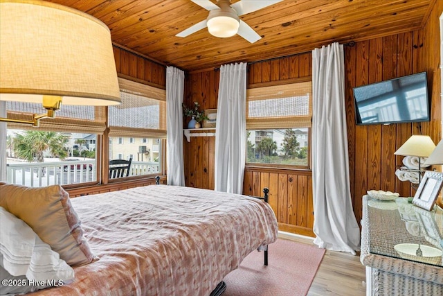 bedroom with wood ceiling, wood finished floors, and wooden walls