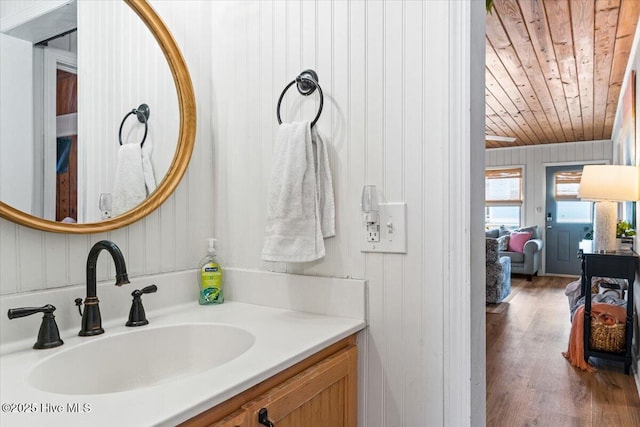 bathroom with wooden ceiling, vanity, wood walls, and wood finished floors