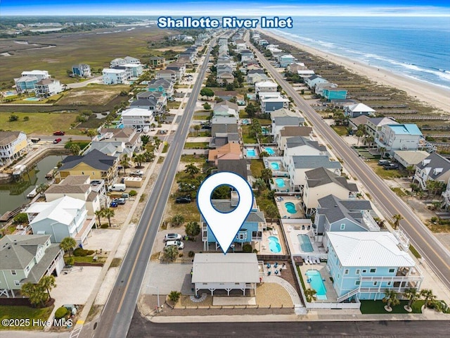 drone / aerial view featuring a water view, a residential view, and a view of the beach