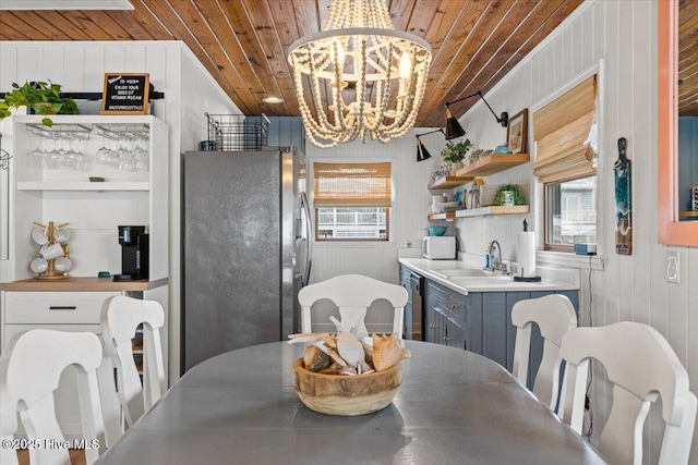 dining room featuring wooden walls, a chandelier, and wood ceiling