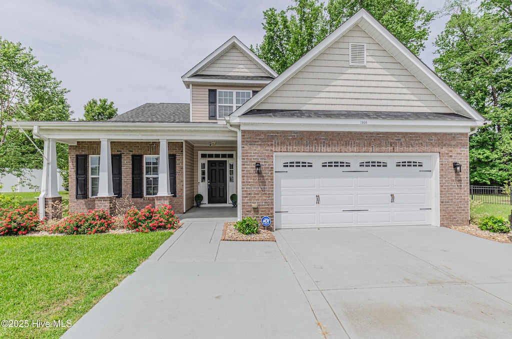 craftsman house with concrete driveway, fence, a garage, and brick siding
