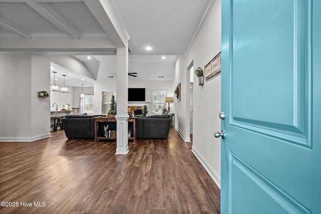 entryway featuring a stone fireplace, baseboards, dark wood-style floors, and a wealth of natural light