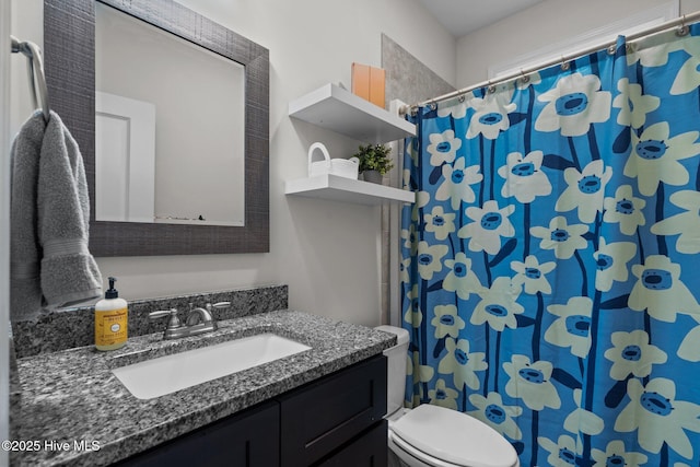 full bathroom featuring toilet, curtained shower, and vanity