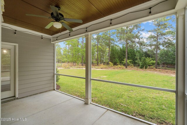 unfurnished sunroom featuring a ceiling fan