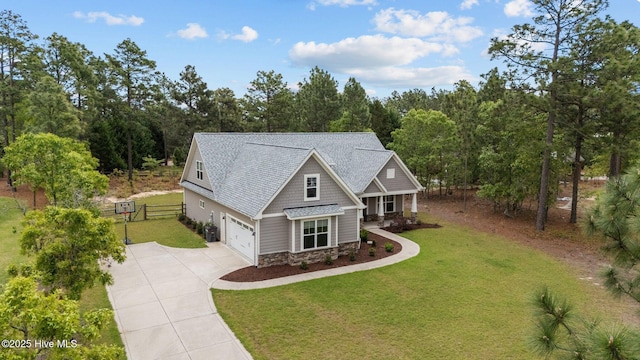 craftsman inspired home featuring covered porch, concrete driveway, a front lawn, and stone siding