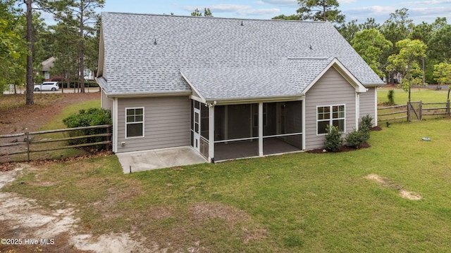 back of house featuring fence private yard, a patio, roof with shingles, a sunroom, and a lawn