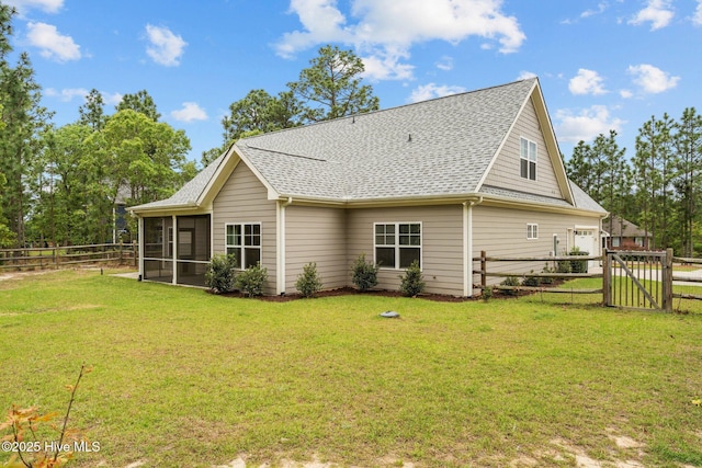 rear view of house featuring a yard, a shingled roof, a fenced backyard, and a sunroom