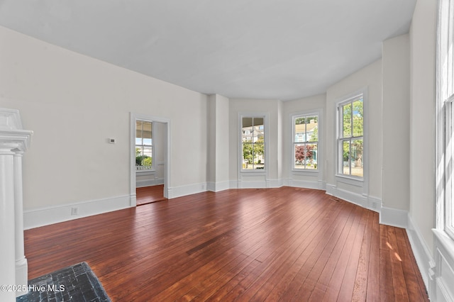 unfurnished living room with dark wood finished floors and baseboards