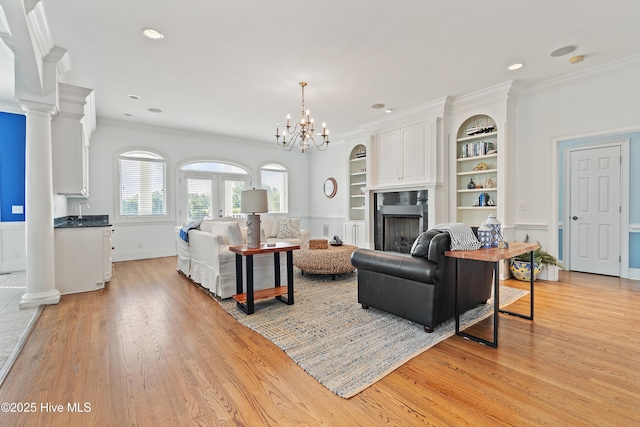 107 Waterway Crossing Ct, Little River, SC 29566 - living room with light wood-type flooring, a fireplace, ornamental molding, built in shelves, and a chandelier