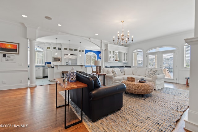107 Waterway Crossing Ct, Little River, SC 29566 - living room featuring ornate columns, crown molding, wood finished floors, a chandelier, and healthy amount of natural light