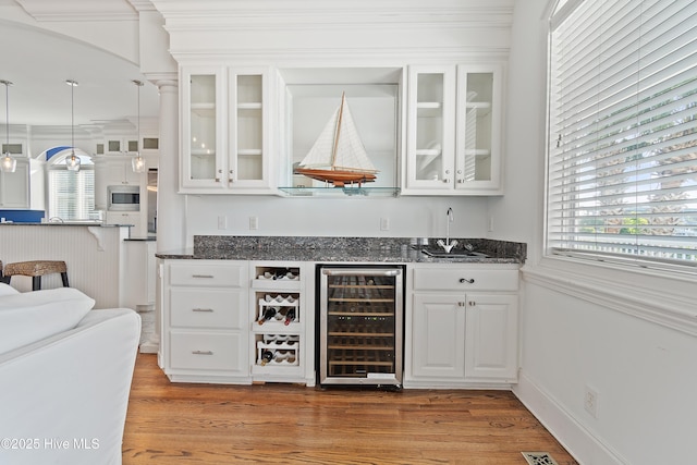 107 Waterway Crossing Ct, Little River, SC 29566 - indoor wet bar featuring wine cooler, stainless steel microwave, light wood-style floors, pendant lighting, and ornamental molding
