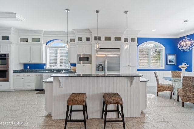107 Waterway Crossing Ct, Little River, SC 29566 - kitchen with built in appliances, crown molding, a breakfast bar area, white cabinets, and a sink