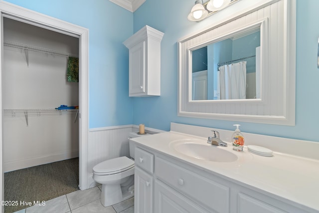 107 Waterway Crossing Ct, Little River, SC 29566 - bathroom with vanity, a wainscoted wall, toilet, tile patterned floors, and a spacious closet