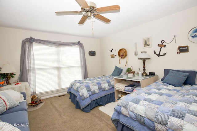 carpeted bedroom with a ceiling fan and visible vents