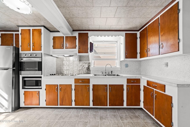 480 Croatan St, Belhaven, NC 27810 - kitchen featuring decorative backsplash, brown cabinets, a sink, light countertops, and stainless steel appliances