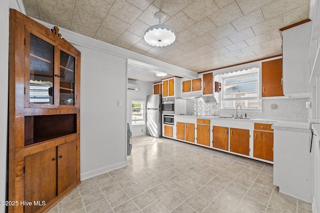 480 Croatan St, Belhaven, NC 27810 - kitchen featuring brown cabinetry, freestanding refrigerator, decorative backsplash, and light countertops