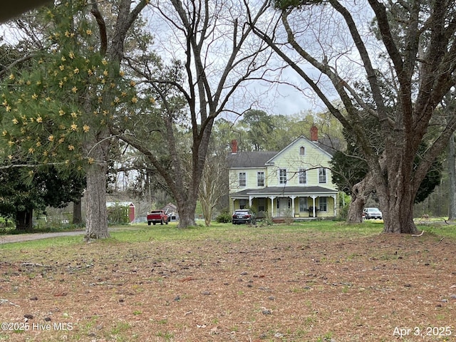 view of front of house featuring a porch and a chimney