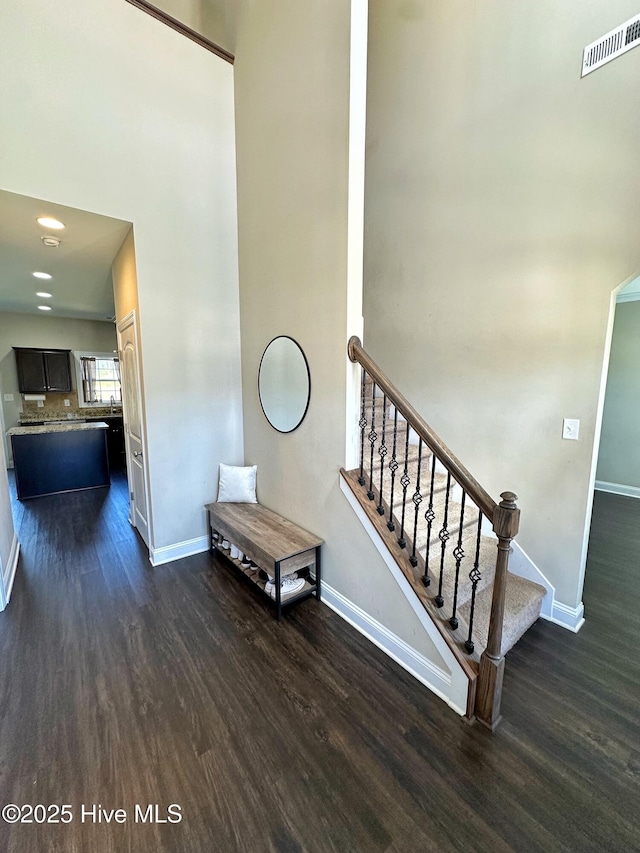 stairs featuring baseboards, visible vents, and wood finished floors