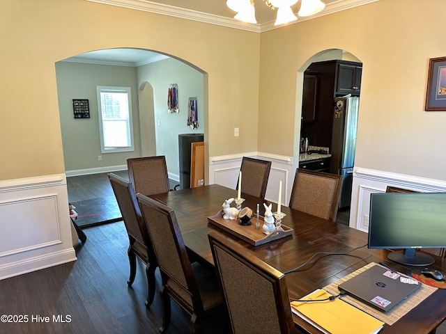 dining area featuring ornamental molding, dark wood-style floors, and arched walkways