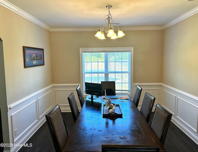 dining room featuring ornamental molding, a notable chandelier, wainscoting, and a decorative wall