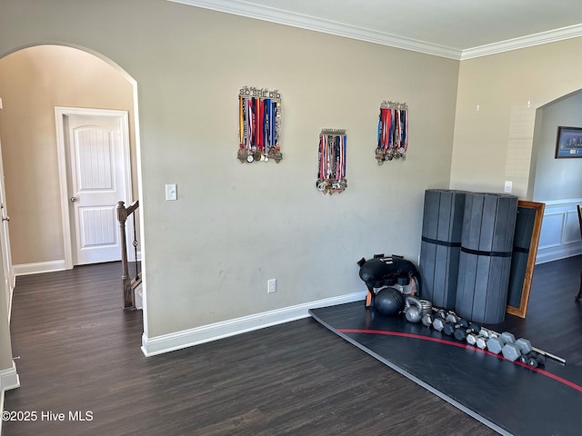 interior space featuring ornamental molding, arched walkways, baseboards, and dark wood-type flooring