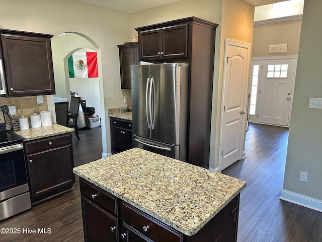 kitchen featuring light stone counters, dark wood-style flooring, and appliances with stainless steel finishes