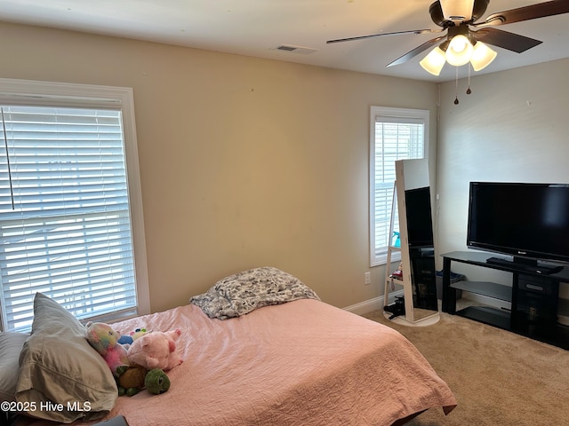 carpeted bedroom featuring visible vents, ceiling fan, and baseboards