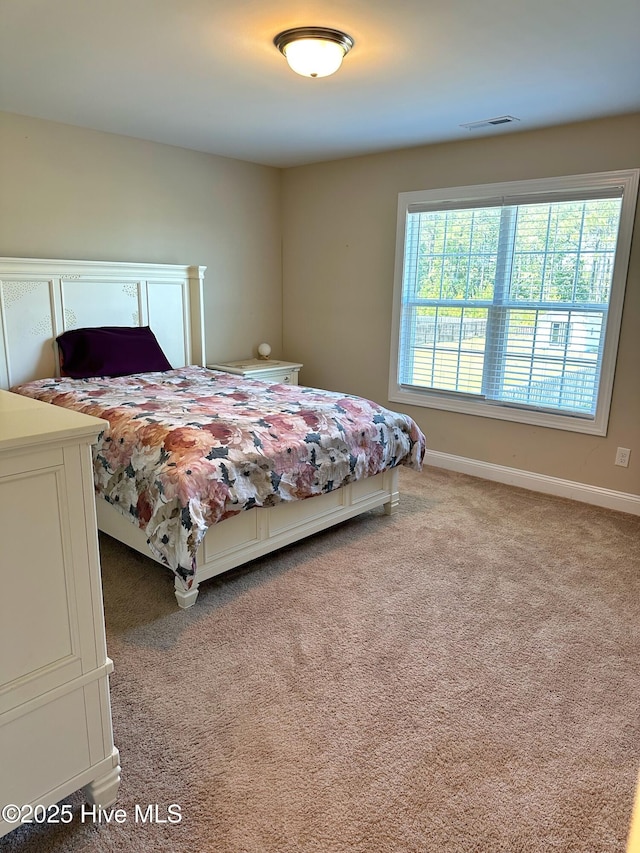 carpeted bedroom featuring baseboards and visible vents