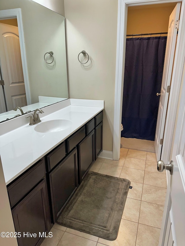 bathroom featuring tile patterned floors, baseboards, a shower with shower curtain, and vanity