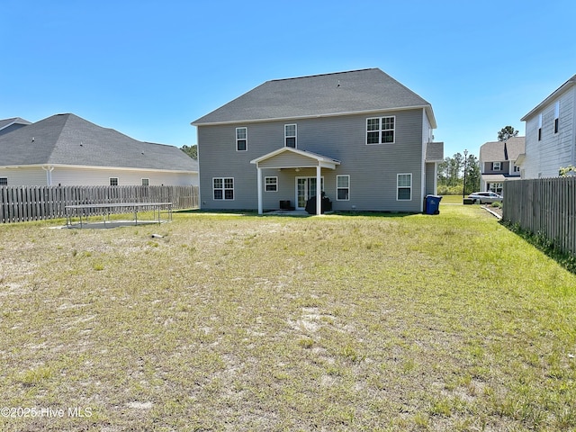 back of house with fence and a lawn
