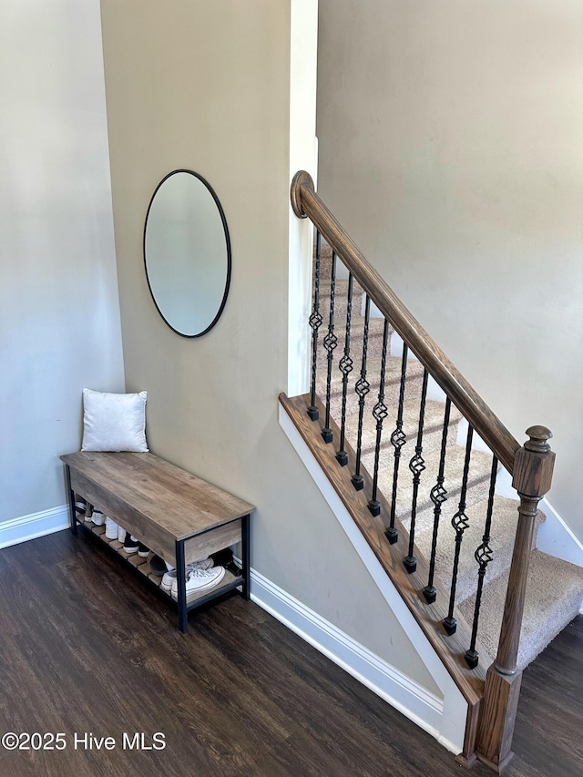 staircase with baseboards and wood finished floors
