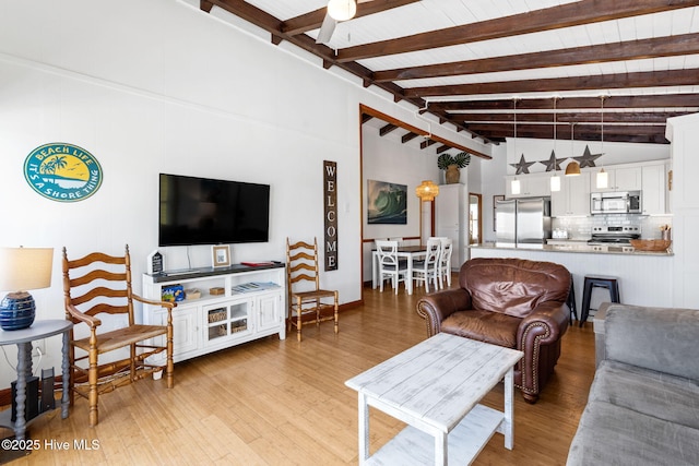 living room featuring light wood-style floors and lofted ceiling with beams