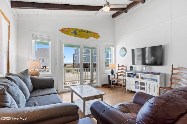 living area with lofted ceiling with beams, a ceiling fan, and wood finished floors