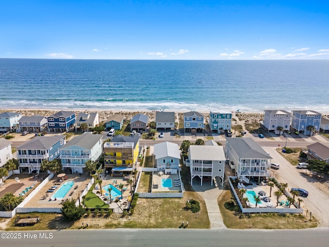 drone / aerial view featuring a residential view, a view of the beach, and a water view