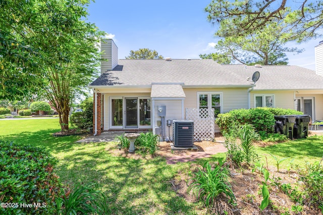 3012 Remington Dr, Wilmington, NC 28405 - rear view of house with roof with shingles, brick siding, a chimney, cooling unit, and a yard