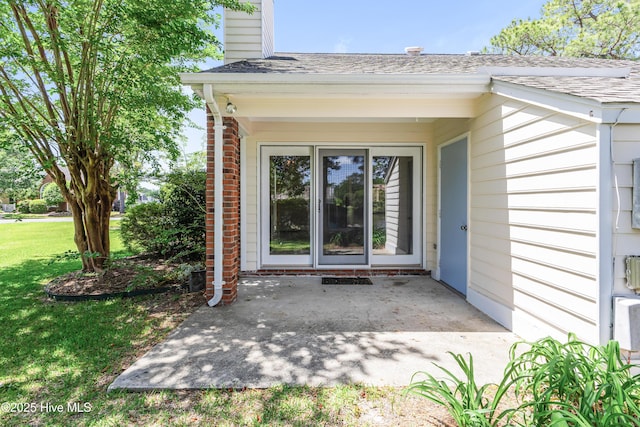 3012 Remington Dr, Wilmington, NC 28405 - property entrance with a patio, a shingled roof, a lawn, and a chimney