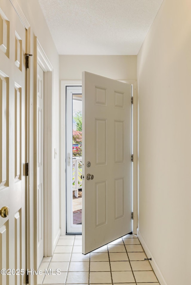 3012 Remington Dr, Wilmington, NC 28405 - entryway with light tile patterned floors, baseboards, and a textured ceiling