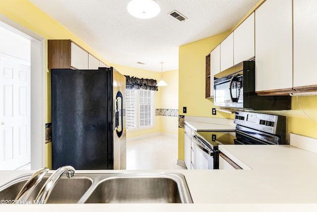 3012 Remington Dr, Wilmington, NC 28405 - kitchen featuring white cabinets, a sink, light countertops, visible vents, and black appliances