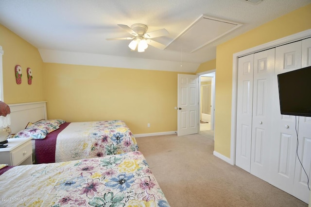 bedroom featuring light colored carpet, attic access, lofted ceiling, and a closet
