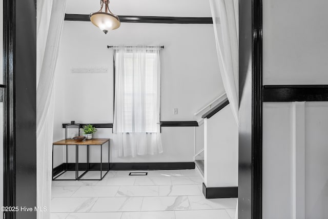 entryway featuring stairs, marble finish floor, and baseboards
