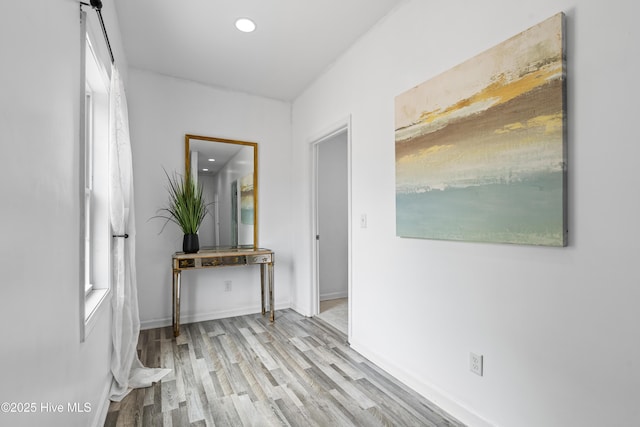 hall with wood finished floors, recessed lighting, and baseboards